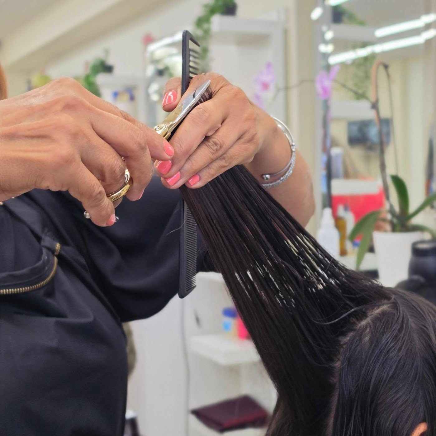 A Perfect Cuts stylist cutting a client's hair with scissors and comb